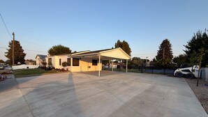A residential area with a house, a covered patio, and a paved driveway. - Vernal Sport Court Base Camp (Vernal)