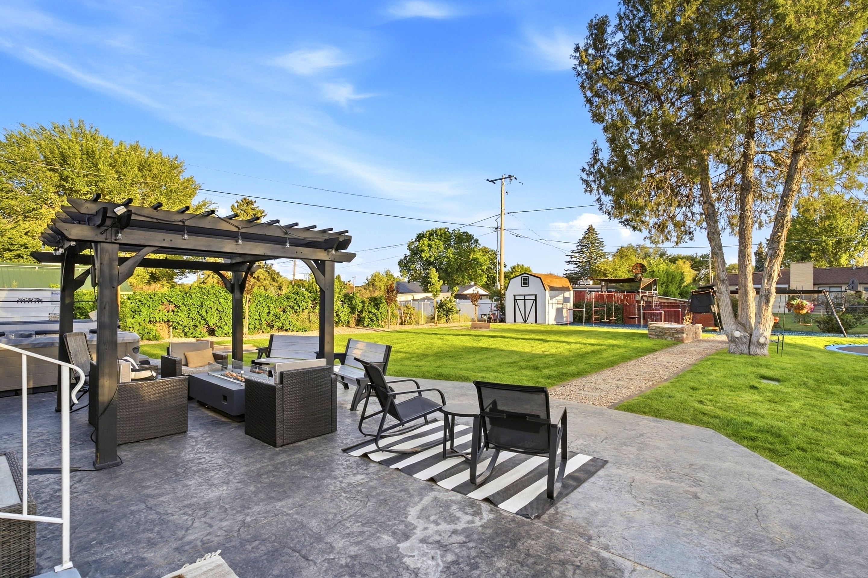 Un espace extérieur aménagé en terrasse, avec une pergola, des sièges et un barbecue.