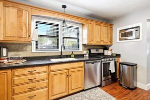 A kitchen with wooden cabinets, a stainless steel dishwasher, an oven, and a microwave. - RV full hook up  RV full hook up (Vernal)