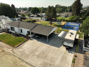 A residential area with a house featuring a covered garage, a swimming pool, and a mobile home labeled "HIDEOUT".