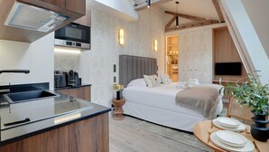 Une chambre à coucher moderne avec un lit, une table de chevet et un téléviseur.