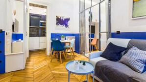 Una sala moderna con un sofá, una mesa de centro y un comedor con sillas y una mesa.