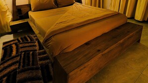 Una cama grande con estructura de madera y cubrecama marrón.