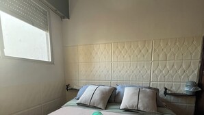 A hotel room with a bed, pillows, and rolled towels. - Parque Rodó | Private terrace | BBQ (Montevideo)