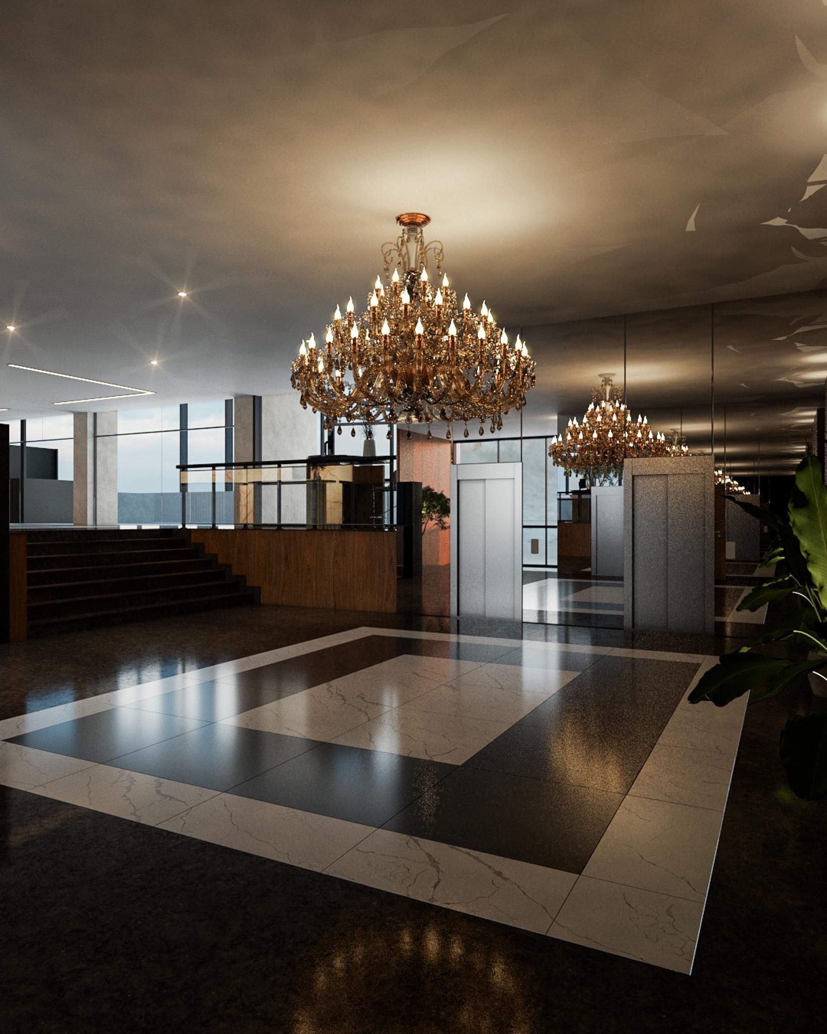 A spacious lobby with a grand chandelier, a reception desk, and a staircase leading to upper floors.