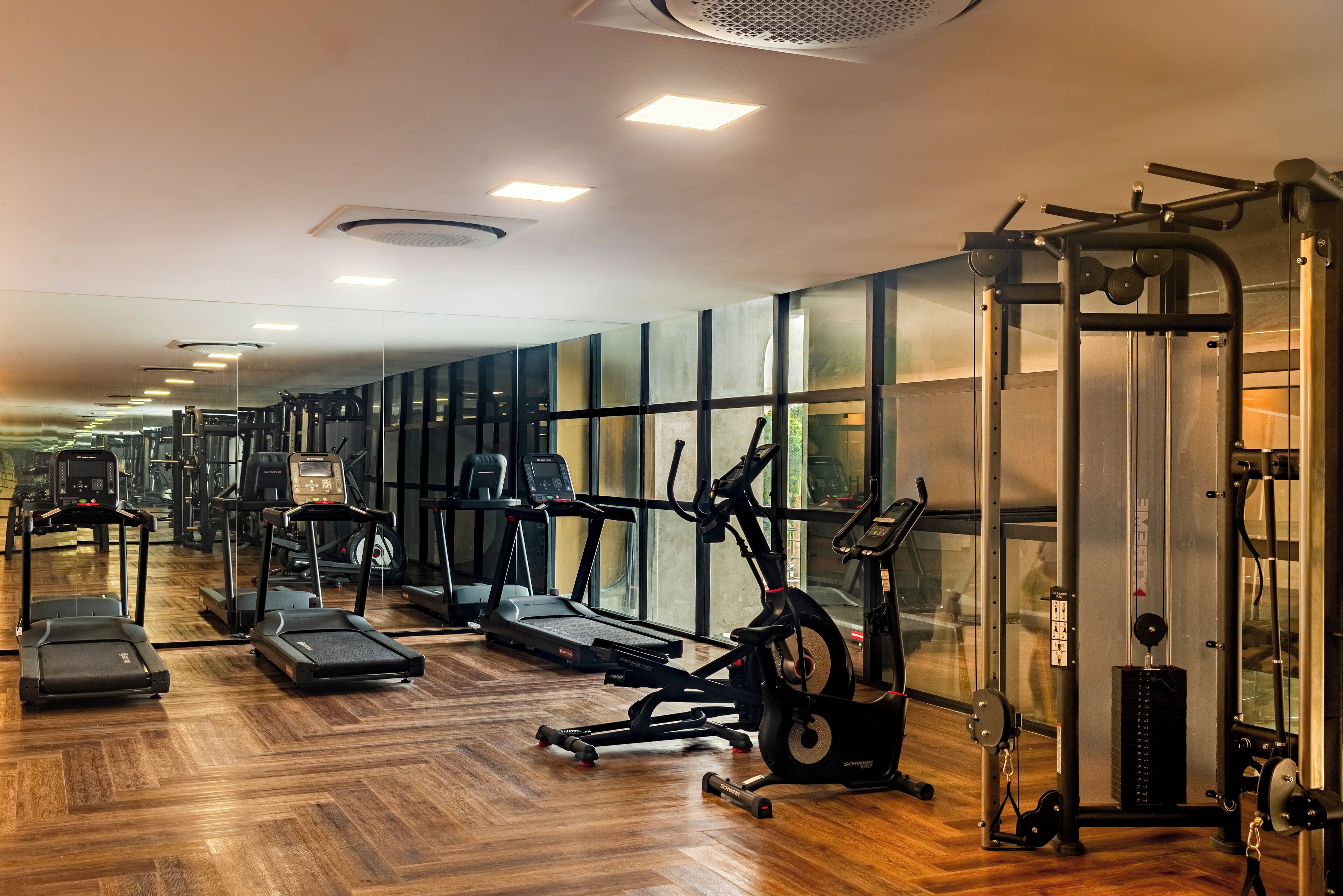A gym with treadmills, elliptical machines, and weightlifting equipment.