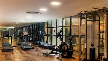 A gym with treadmills, elliptical machines, and weightlifting equipment.