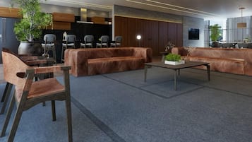 A modern interior with sofas, chairs, a coffee table, and a potted plant.
