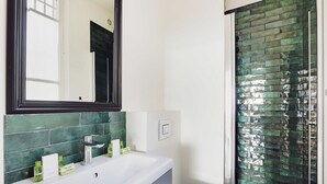 A bathroom with a white sink, green-tiled shower, and a mirror above the sink. - Luxurious Apartment - 3br/6p - Nation (Paris)