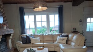 A cozy living room with a large beige sectional sofa, a wooden coffee table, a woven rug, and a white lantern. - Laurette - Family home, Somme Valley (Sailly-Laurette)