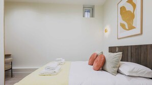 A hotel room with a bed, a small window, a framed artwork, and a chair. - Cosy Apartment - 1br/2p- Saint-cloud (Saint-Cloud)