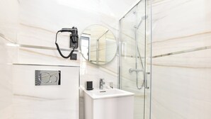 A modern bathroom with a glass shower enclosure, a white sink, and a hairdryer mounted on the wall. - Charming Apartment - 2br/7p - Arc de Triomphe (Paris)