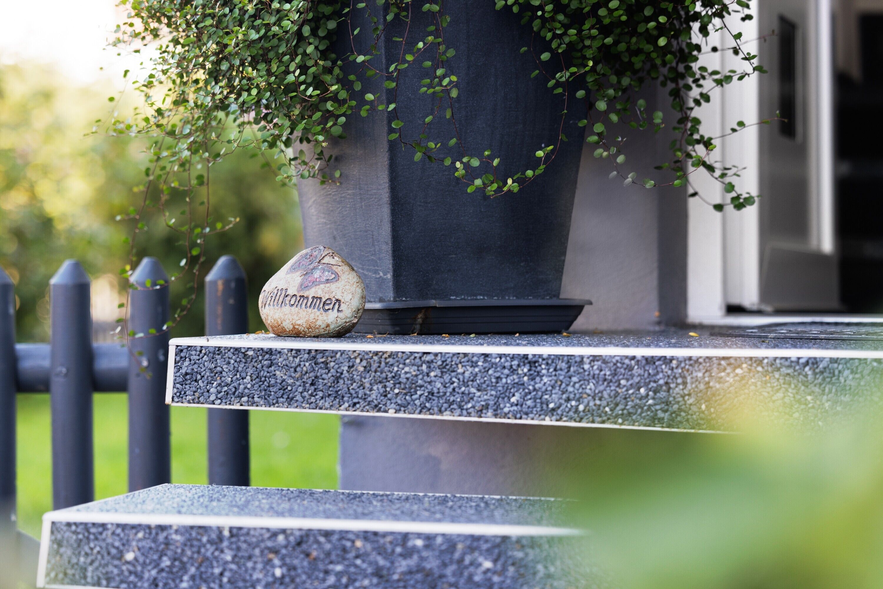 A stone bench with a potted plant and a stone with 'Wittkönnen' engraved on it.