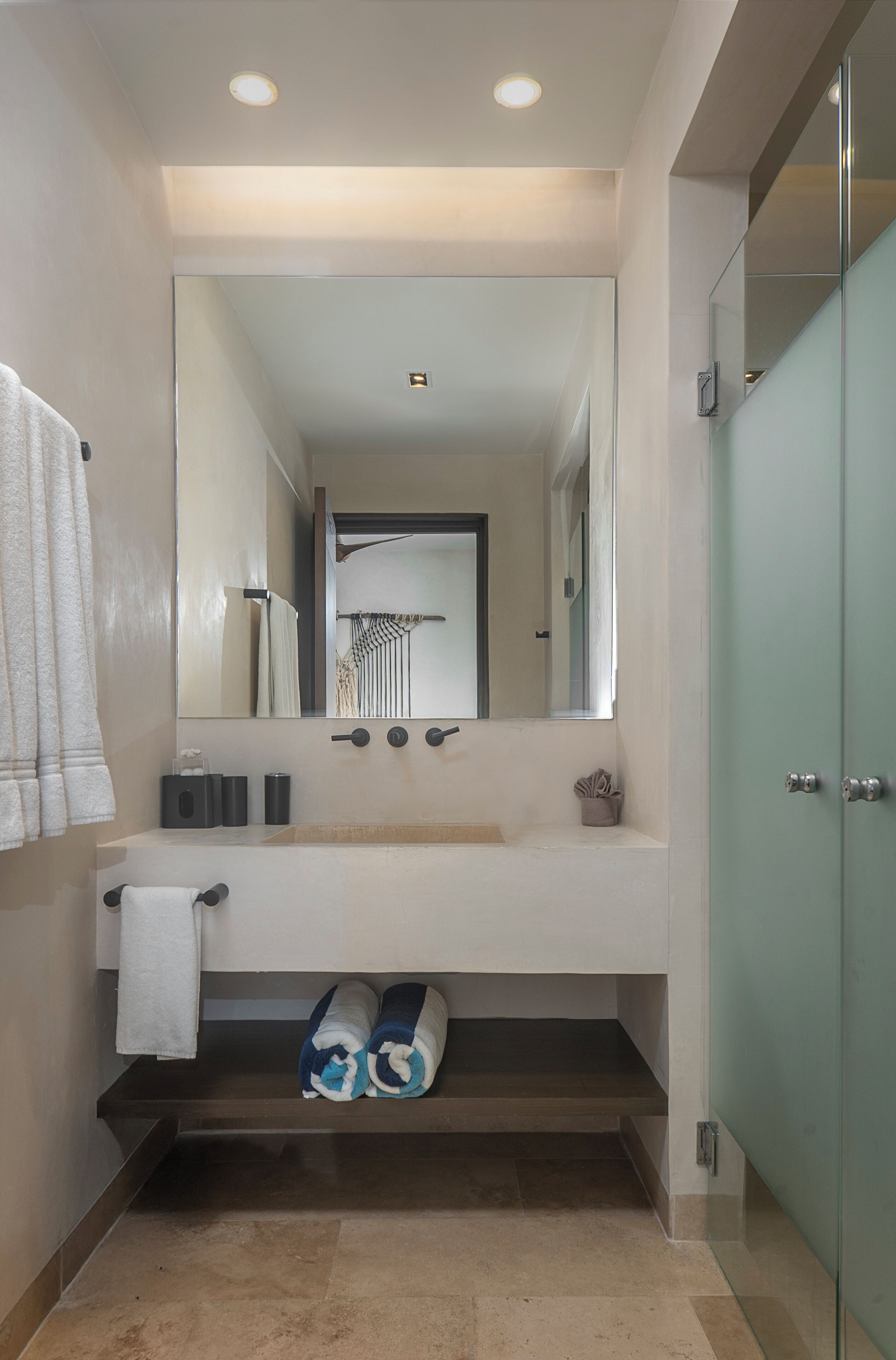 Een moderne badkamer met een grote spiegel, een wastafel en een handdoekrek.