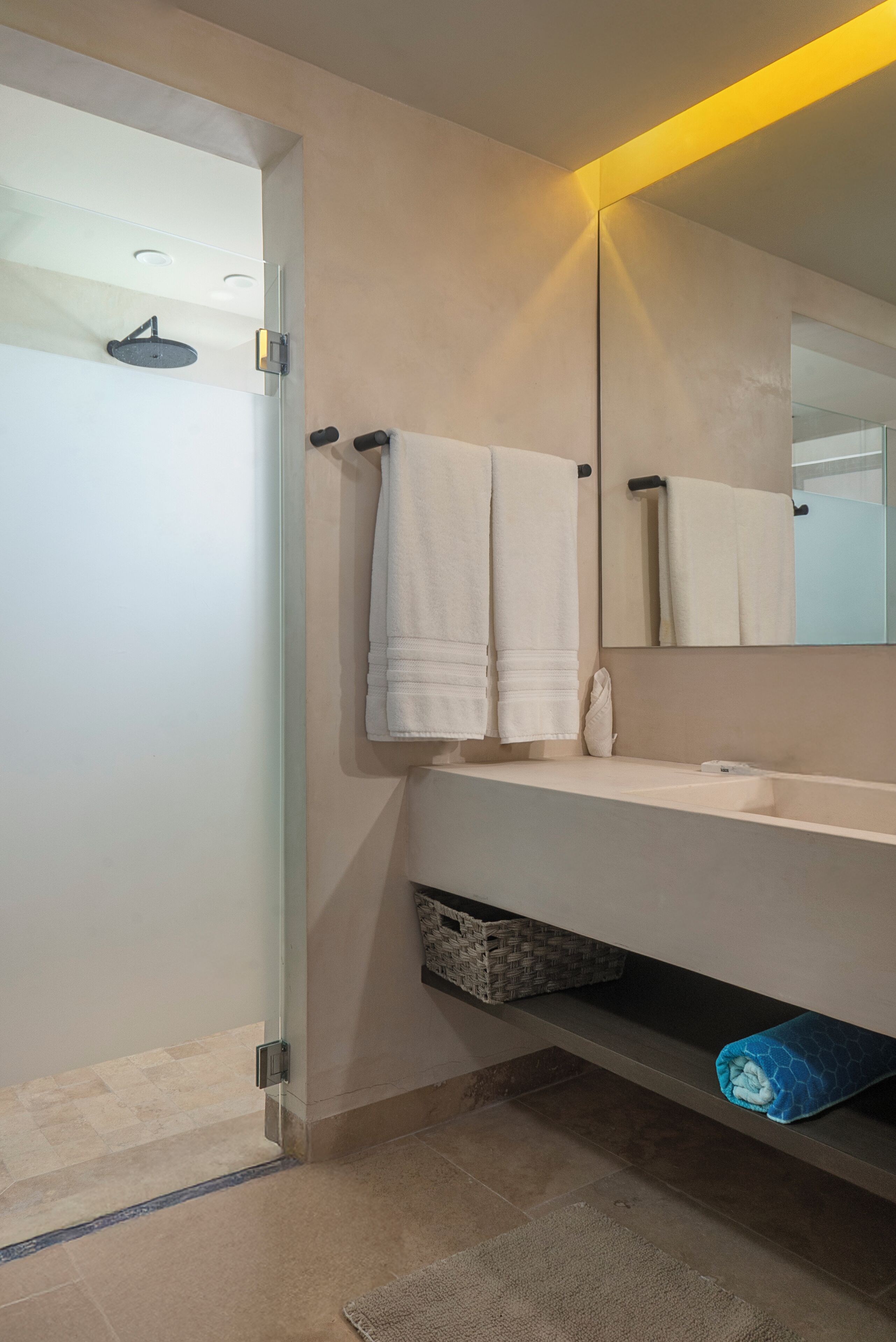 A modern bathroom with a glass shower enclosure, a white sink, and a large mirror.