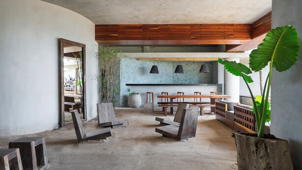 A spacious indoor area with a concrete floor, wooden benches, and a large potted plant. - Antal by Beach Please Tulum (Tulum)