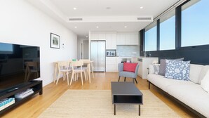 A modern apartment with a living room, dining area, kitchen, and a large window. - Bright 1BR Apartment with Stunning Views (Turner)