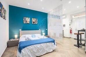 Een moderne hotelkamer met een groot bed, een nachtkastje, een bureau en een decoratief wandpaneel.