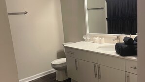 Une salle de bain moderne équipée de toilettes, d’un lavabo et d’un miroir.