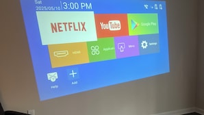 Une projection d’une interface numérique affichant des icônes d’applications, notamment Netflix, YouTube et Google Play.