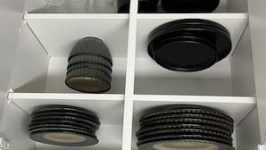 Un meuble de rangement doté de plusieurs étagères où sont rangés divers ustensiles de cuisine.