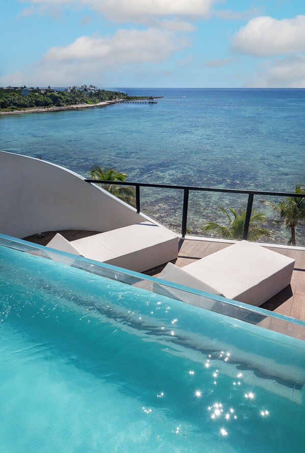 Una piscina con vistas al océano y un muelle distante.