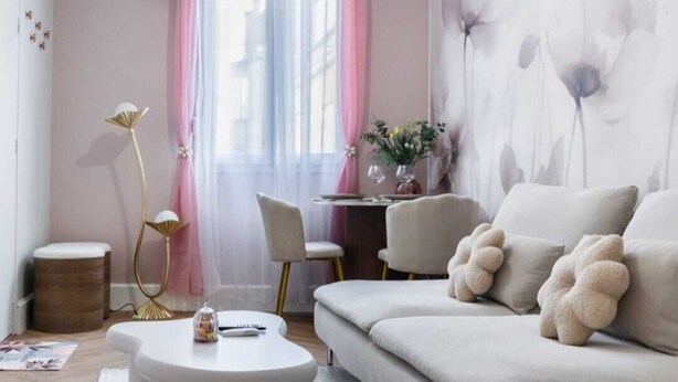 A modern living room with a sofa, a round coffee table, and a floor lamp. - La Parenthèse Fleurie – Suite with spa and projector screen in Bergerac (Bergerac)