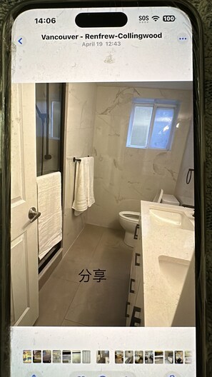 A bathroom with a toilet, sink, and a window. - Cozy retreat in a classic home (Vancouver)