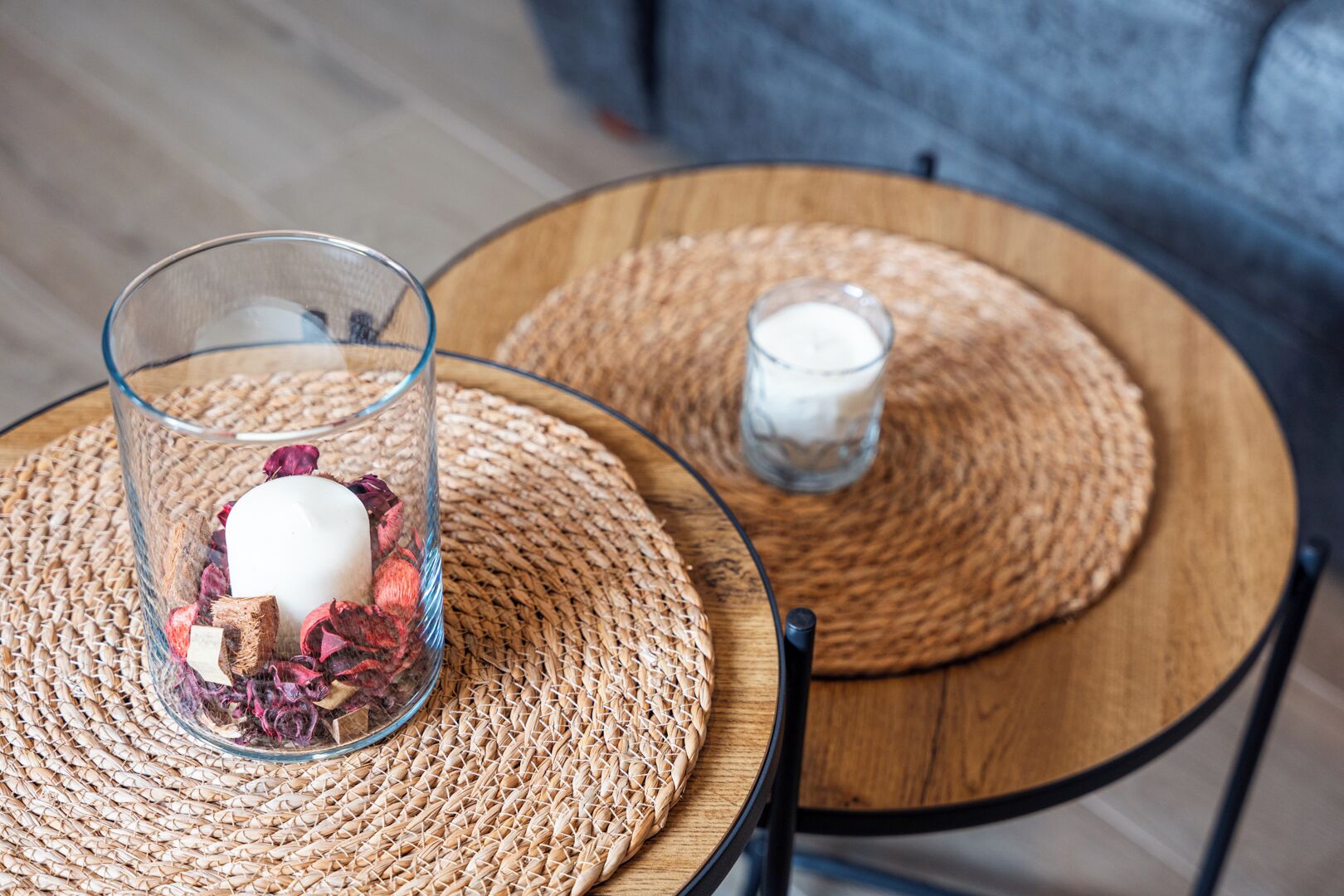 Et glas mælk på en vævet underlag, et glas med en hvid genstand, og en vævet underlag på et rundt træbord.