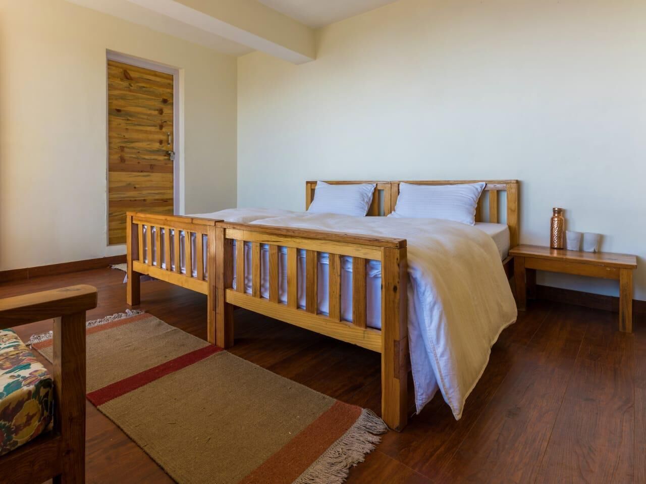 A bedroom with a wooden bed, a bedside table, and a bench.