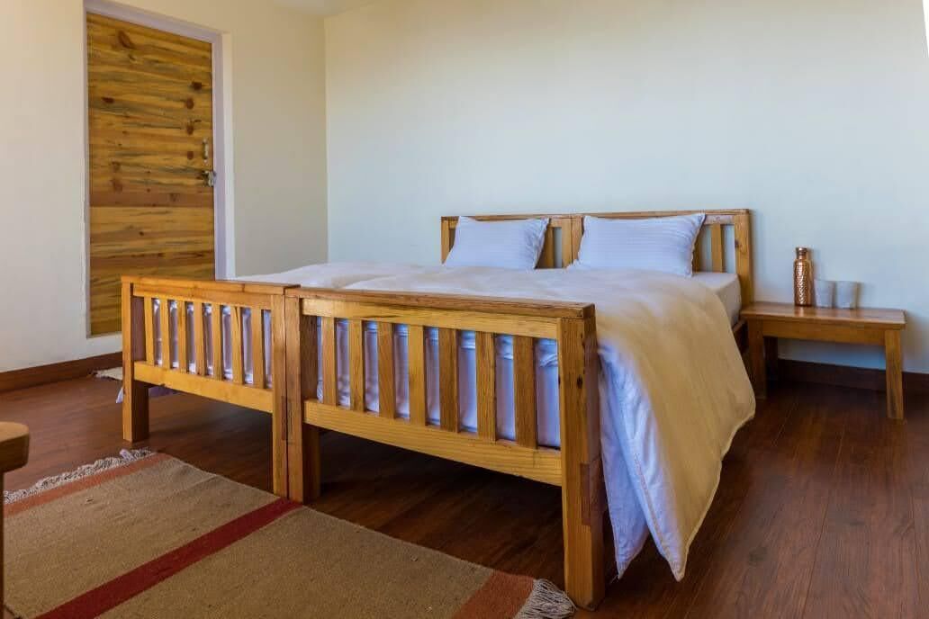 A bedroom with a wooden bed, a nightstand, and a door with a wooden panel.