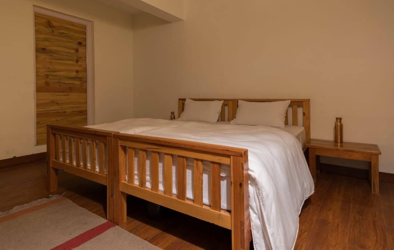 Un dormitorio con una cama de madera, una mesita de noche y un armario de madera.