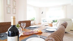A dining area with a wooden table set for two, featuring a bottle of wine, glasses, and a charcuterie board. - Spacious, good located villa in Sant Pere Pescador (Sant Pere Pescador)