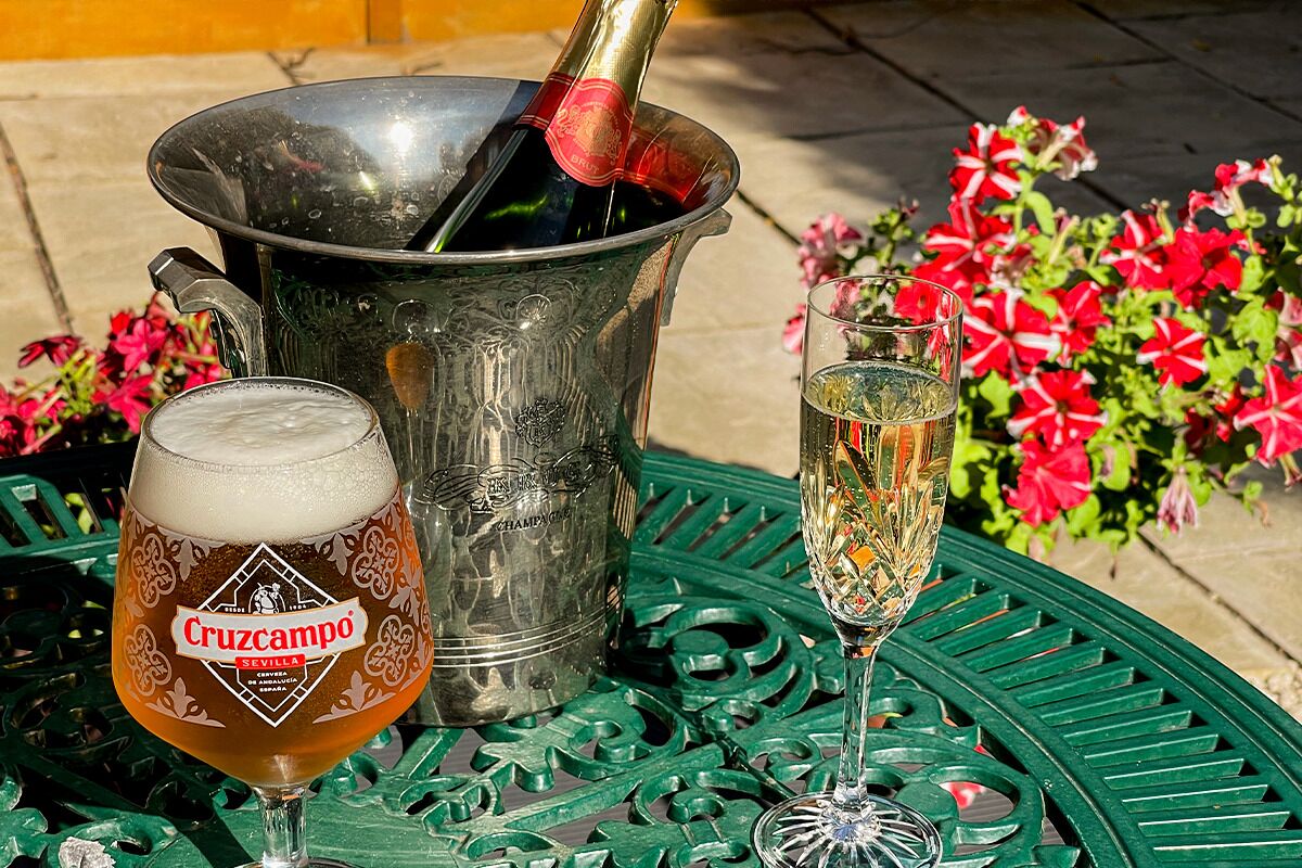 Una mesa con un cubo metálico, una jarra de cerveza y una copa de champán.