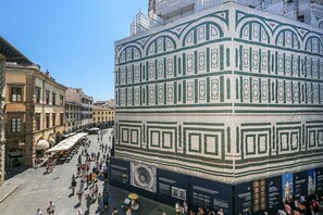 A historic building with a large, ornate facade, a central courtyard, and a bustling street scene.