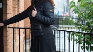 A person standing by a building entrance holding an umbrella. - Finnieston 1BR | Walk to Hydro & SEC | Parking (Glasgow)