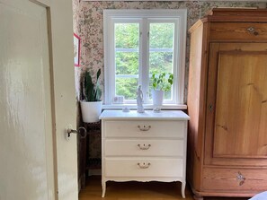 A room with a white dresser, a wooden cabinet, and a window with a view of greenery. - 5 Person Holiday Home in Immeln (Immeln)