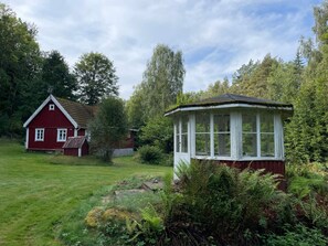 A red house with a white porch and a garden in front. - 5 Person Holiday Home in Immeln (Immeln)