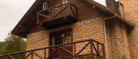 A rustic stone building with a wooden balcony.