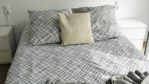 A bedroom with a bed, pillows, a blanket, and a towel. - SEA HOUSE Madeira (Funchal)