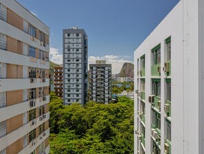 A high-rise building with multiple floors, surrounded by lush green trees. - Apto a 700m da Praia do Leblon com Wi-fi e ar (Rio de Janeiro)