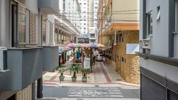 A narrow street with outdoor seating and umbrellas, a sign for 'Lounge Bar', and a 'Hotel' sign.