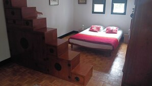 Un dormitorio con cama, cómoda, ventana y puerta.