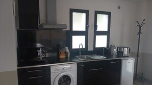 Cocina compacta con lavadora, cafetera y tostadora.