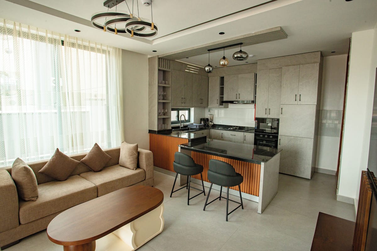 A modern kitchen with a central island, built-in cabinets, and pendant lighting.