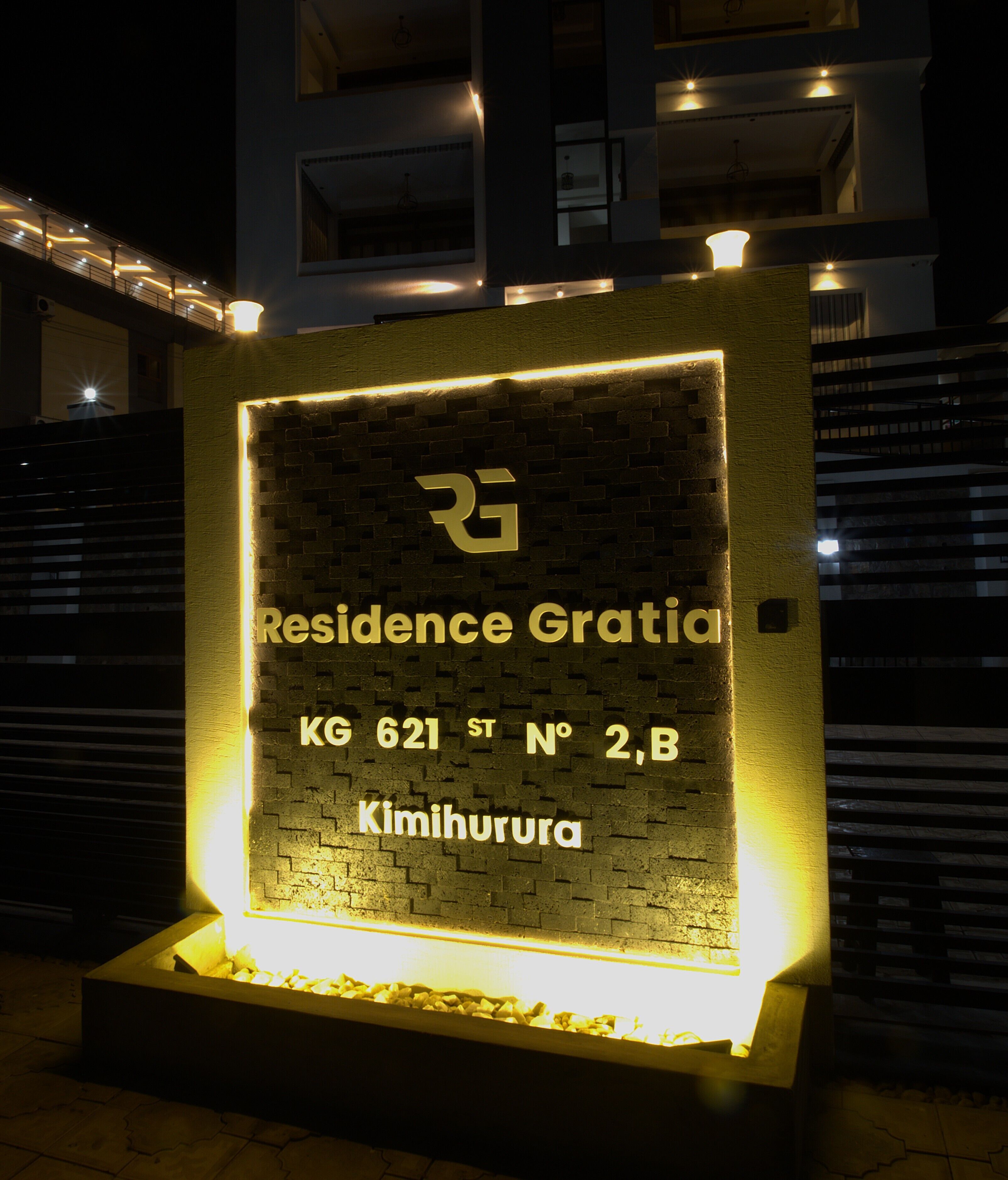 A lit signboard with the text "Residence Gratia KG 621 ST N° 2B, Kimihurura" indicating a residential address.