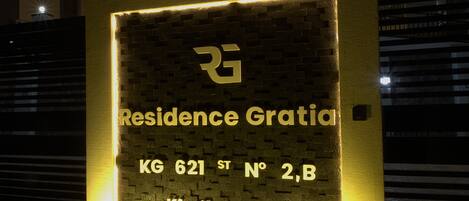 A lit signboard with the text "Residence Gratia KG 621 ST N° 2B, Kimihurura" indicating a residential address.