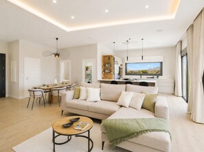 Ein modernes Wohnzimmer mit einer Couch, einem Couchtisch und einem Essbereich.