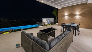 A modern outdoor living area with a pool, seating, and a dining setup. - Cubo's Villa Giava / private pool / air conditioning / free Wi-Fi (Alhaurín el Grande)