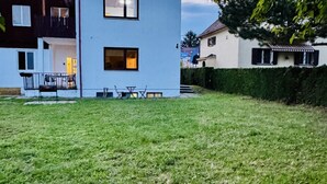 A modern two-story building with a well-maintained lawn, outdoor seating, and a visible balcony. - Beautiful & Lovely Stay | Prime Spot by Belvedere (Vienna)